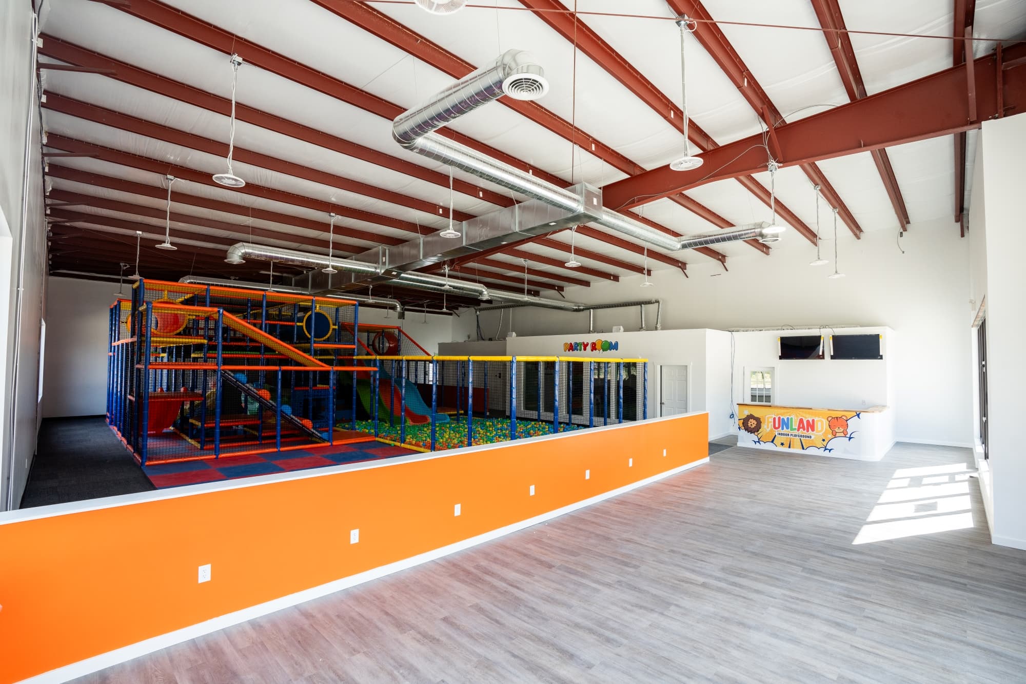 Indoor commercial playground with colorful slides, ball pit, and padded flooring designed for children installed by AY Remodeling & Restoration