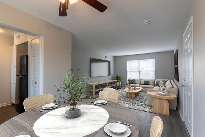A renovated apartment dining and living area with updated flooring, neutral paint, and modern staging after fire restoration by AY Remodeling.