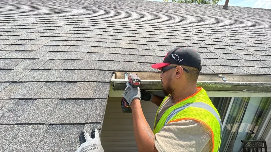 Technician performing professional gutter installation services on an apartment complex in Greenwood, Indiana