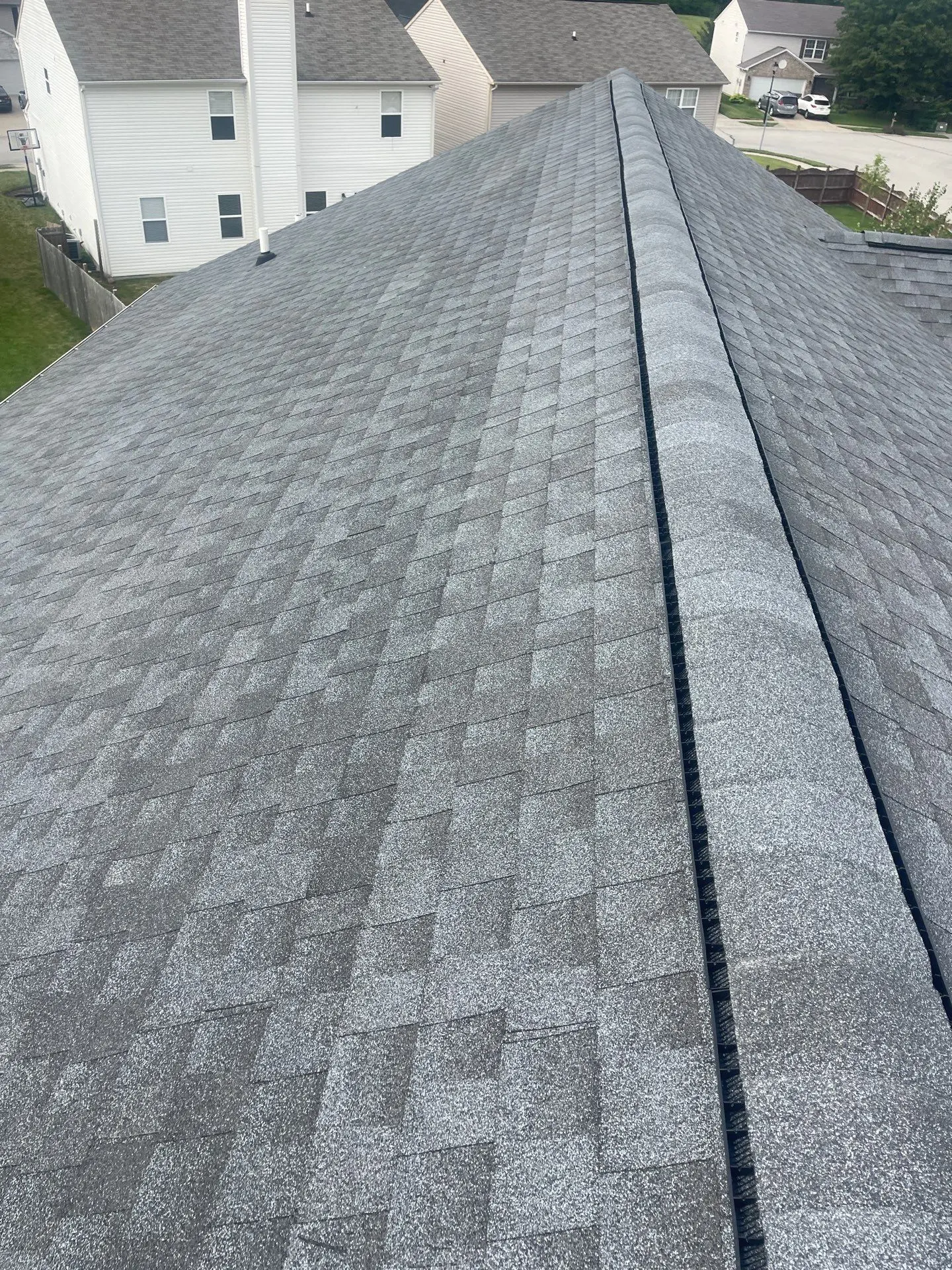 Finished residential roofing project with new shingles and ridge vent installation in Fishers, Indiana.
