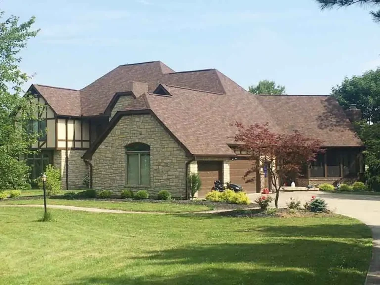 Completed roof replacement on a stone exterior home with architectural shingles by AY Remodeling & Restoration