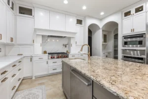 Modern kitchen remodel with white cabinets, large island, quartz countertops, and stainless steel appliances in Carmel, Indiana