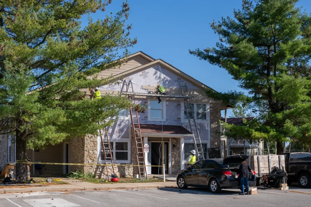 Exterior siding installation in progress at Sandstone Apartments Phase I during renovation project