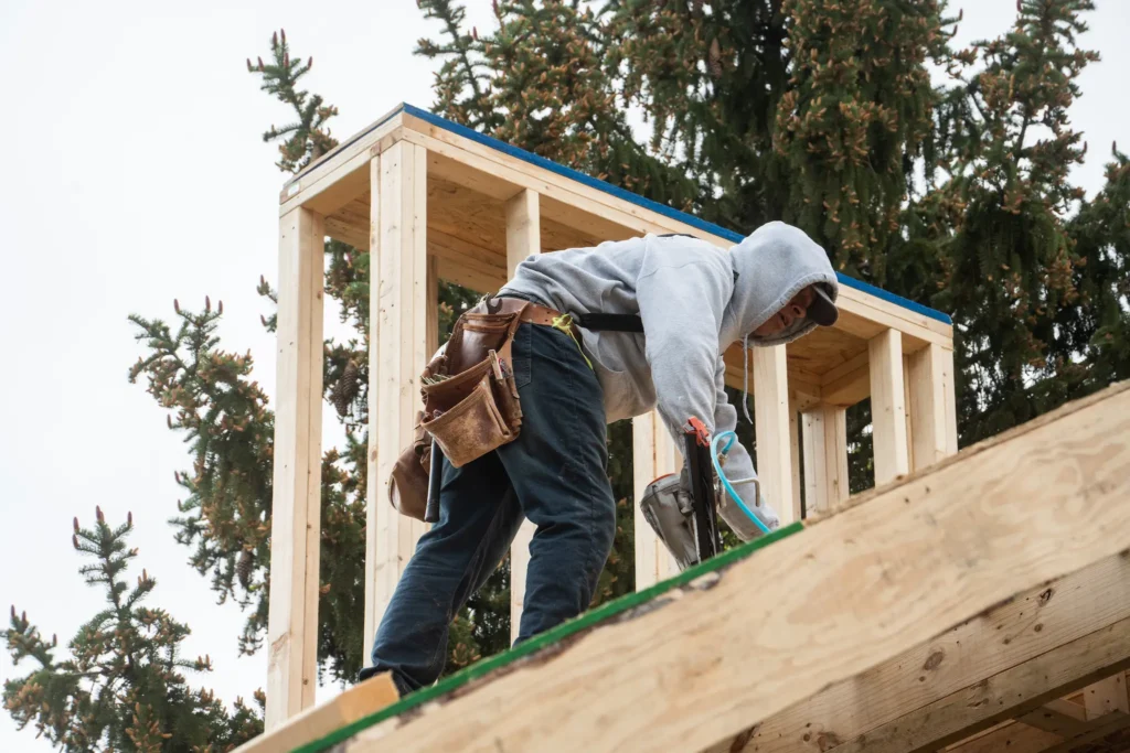 Contractor installing roofing during pool house construction in Carmel, Indiana