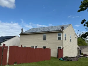 Roofing crew installing synthetic underlayment during wind damage roof replacement project in Noblesville, Indiana