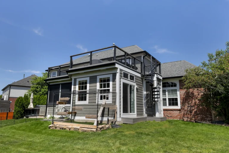 Custom sunroom and rooftop deck addition with spiral staircase access and modern railing system in Carmel, Indiana