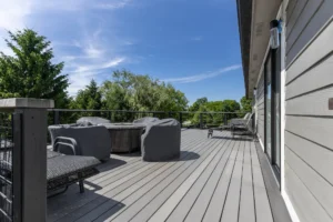 Composite rooftop deck with metal railing and outdoor seating above custom sunroom addition in Carmel, Indiana