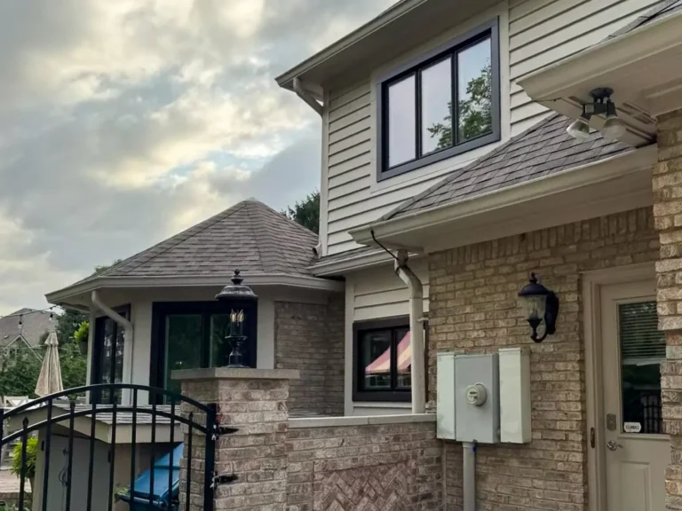 Original gutters and downspouts around the rear roofline before replacement