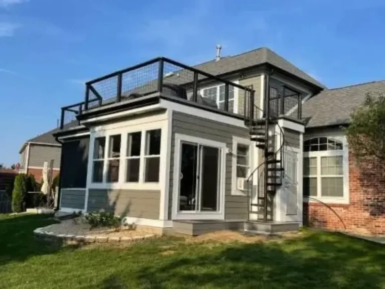 Room addition with updated gray siding and exterior painting completed by AY Remodeling & Restoration before catio addition in Carmel, Indiana.