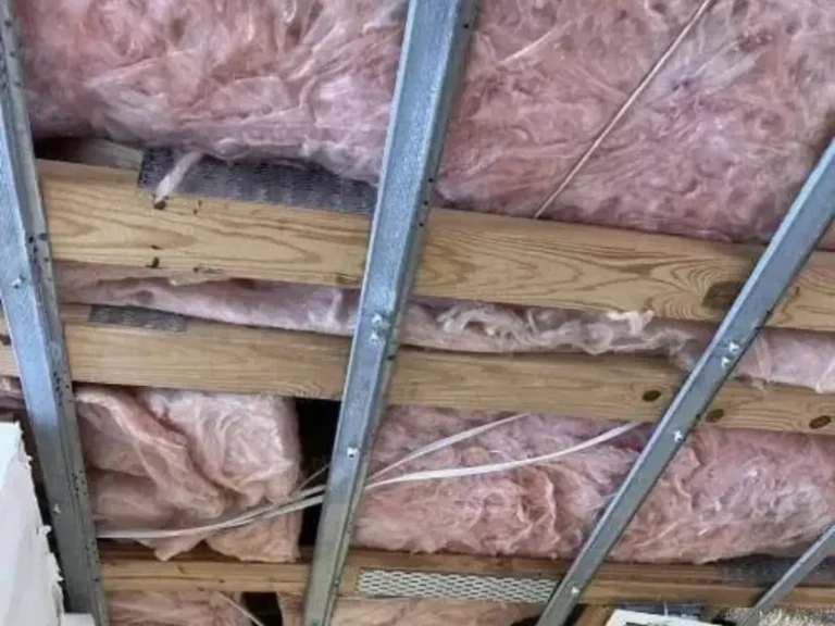 Pink fiberglass insulation installed between ceiling joists during insulation services in Indiana
