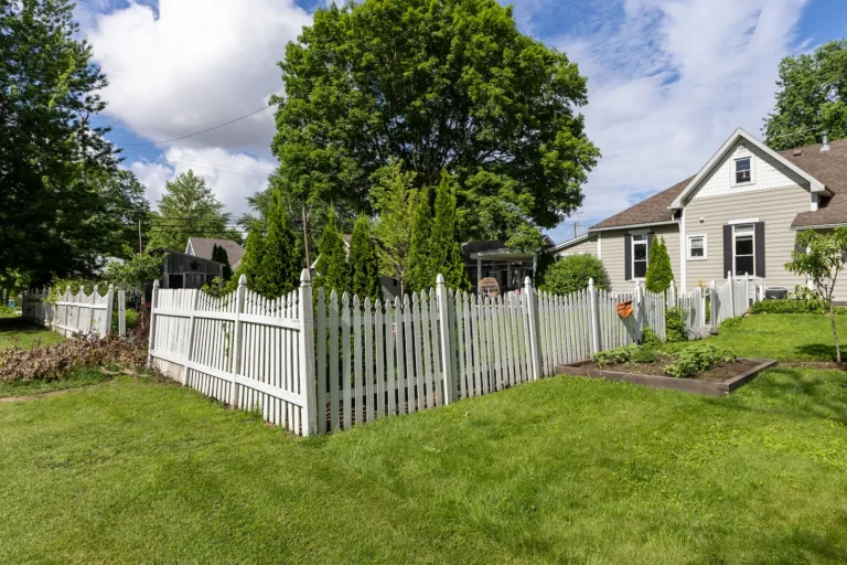 Wide view of the original white picket fence before installation of a new wood privacy fence