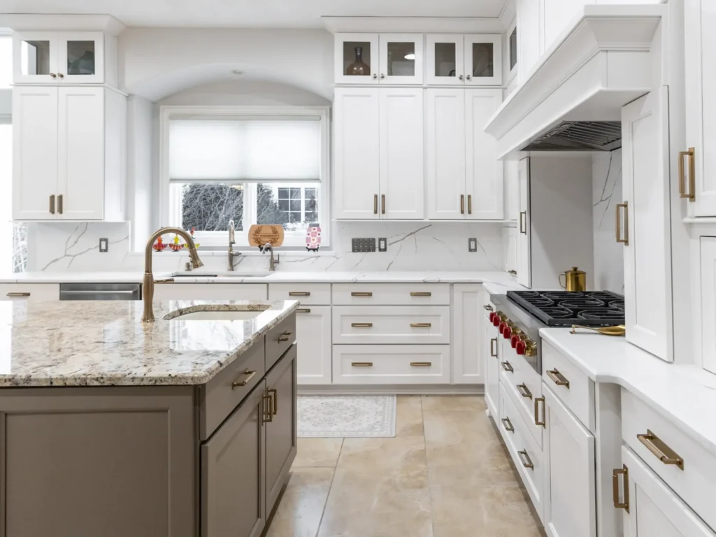 Renovated Carmel kitchen with painted white cabinets, contrasting island, updated countertops, and gold hardware