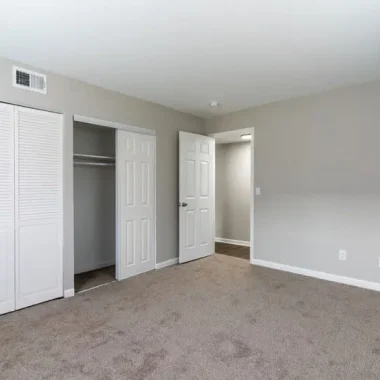Updated bedroom with new carpet, fresh paint, and renovated closet space by AY Remodeling & Restoration.