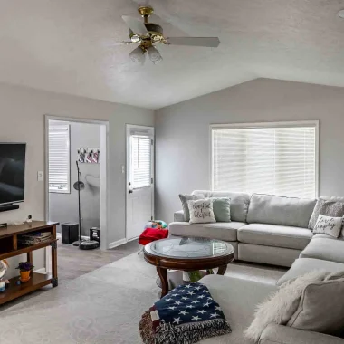 Bright renovated living room with new flooring, paint, and custom layout completed during a lake house addition in North Webster, Indiana by AY Remodeling & Restoration.