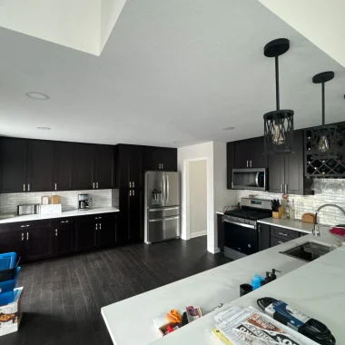 Kitchen remodeling and renovation with dark cabinets, white countertops, and updated lighting in Indiana