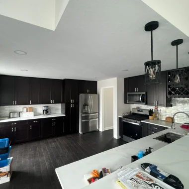 Kitchen remodeling and renovation with dark cabinets, white countertops, and updated lighting in Indiana