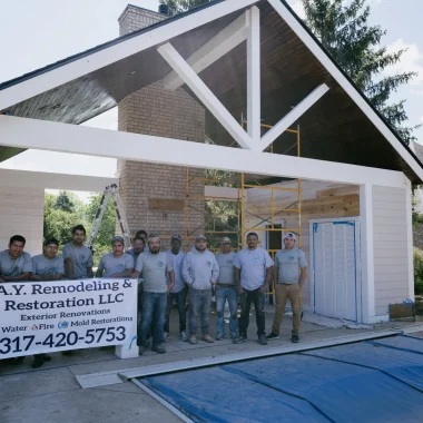 AY Remodeling & Restoration team posing in front of in-progress custom pool house addition